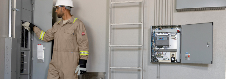 Male employee wearing flame resistant shirt and pants working on an electrical panel